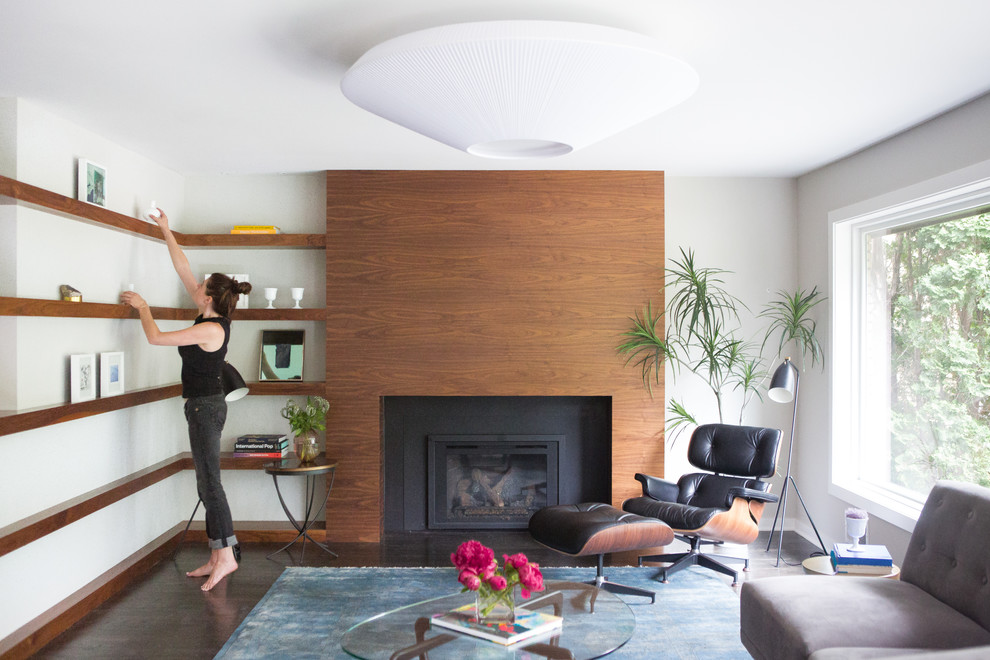 ミネアポリスにあるラグジュアリーな広いミッドセンチュリースタイルのおしゃれな独立型リビング (グレーの壁、濃色無垢フローリング、標準型暖炉、木材の暖炉まわり、テレビなし) の写真