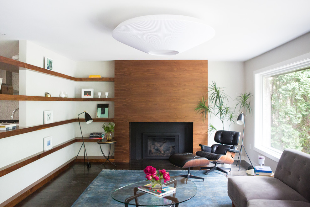 Пример оригинального дизайна: большая изолированная гостиная комната в стиле ретро с серыми стенами, темным паркетным полом, стандартным камином и фасадом камина из дерева без телевизора