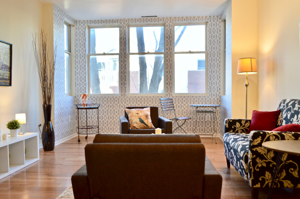Ispirazione per un soggiorno design di medie dimensioni con parquet chiaro, pavimento marrone e carta da parati