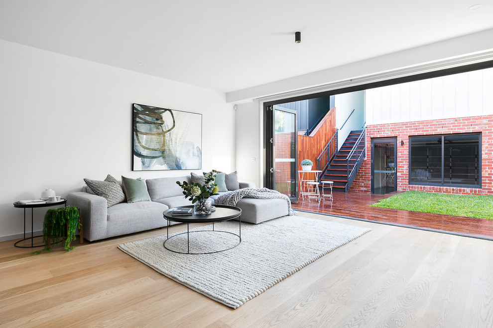 Esempio di un soggiorno moderno aperto con sala formale, pareti bianche, parquet chiaro e pavimento beige