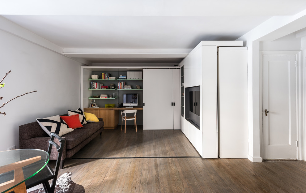 Ispirazione per un piccolo soggiorno minimalista aperto con pareti bianche, pavimento in legno massello medio e parete attrezzata