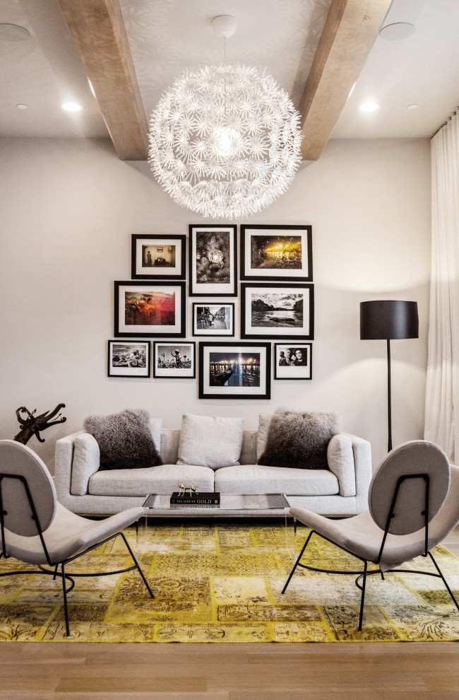 Example of a trendy medium tone wood floor, brown floor and exposed beam living room design in Dallas with beige walls