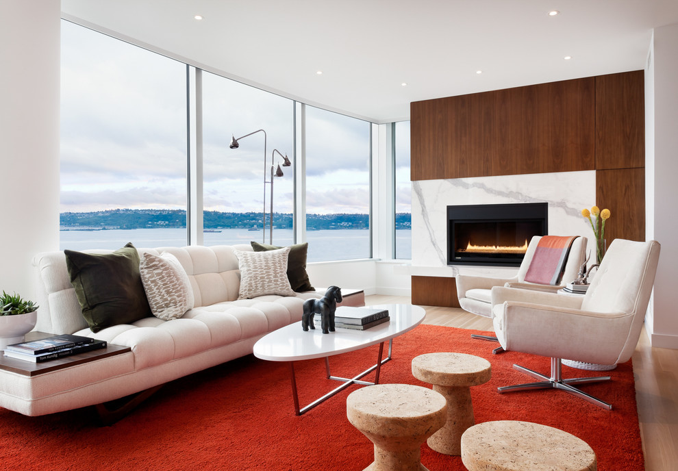 Ispirazione per un soggiorno design con pareti bianche, pavimento in legno massello medio, camino classico e pavimento marrone