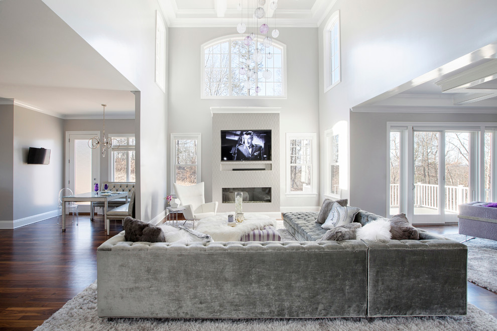 Inspiration for a large contemporary open concept medium tone wood floor living room remodel in New York with gray walls, a standard fireplace, a plaster fireplace and a media wall
