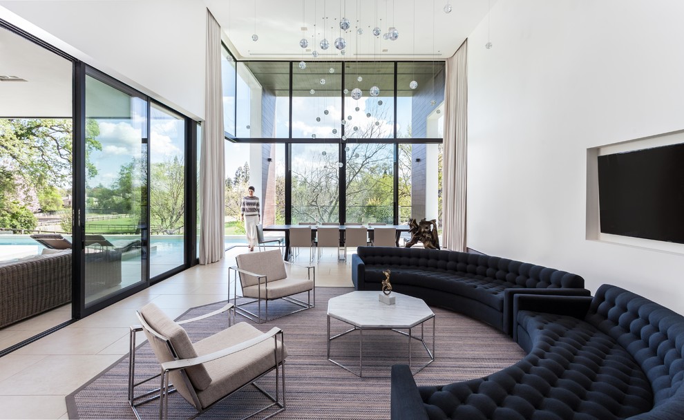 Immagine di un soggiorno minimal aperto con pareti bianche, TV a parete e pavimento beige