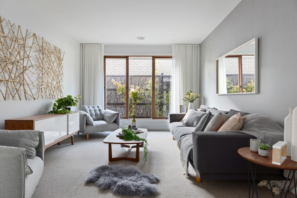 Стильный дизайн: изолированная гостиная комната в скандинавском стиле с серыми стенами и ковровым покрытием без телевизора - последний тренд
