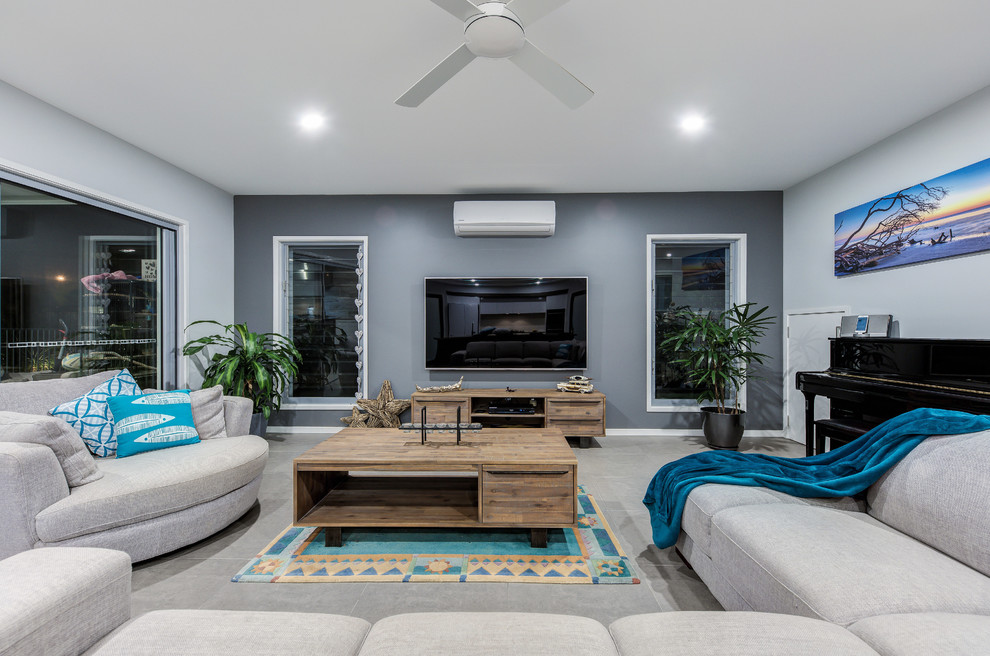 Immagine di un soggiorno design con pareti multicolore, pavimento in gres porcellanato, TV a parete e pavimento grigio