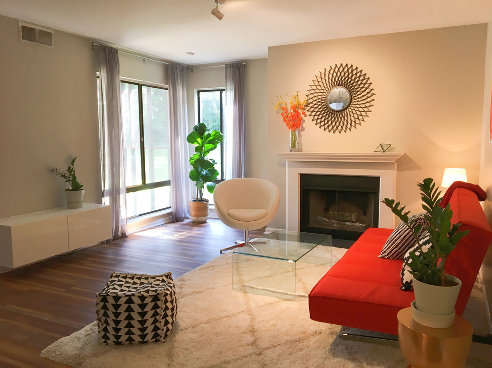 Kleines, Abgetrenntes Modernes Wohnzimmer mit grauer Wandfarbe, Vinylboden, Kaminofen, Kaminumrandung aus Holz und buntem Boden in Charlotte