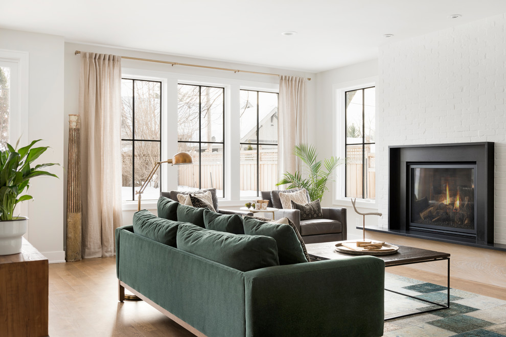 Repräsentatives, Fernseherloses Landhaus Wohnzimmer mit weißer Wandfarbe, hellem Holzboden und Kamin in Minneapolis