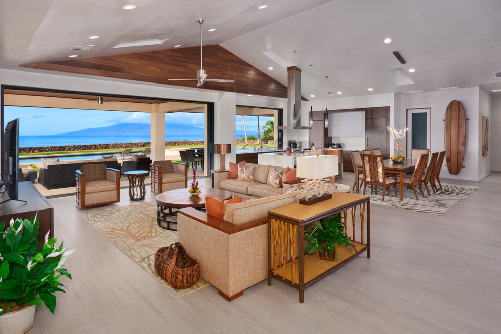 ハワイにある高級な広いトロピカルスタイルのおしゃれなLDK (磁器タイルの床、白い壁、据え置き型テレビ、暖炉なし、ベージュの床) の写真