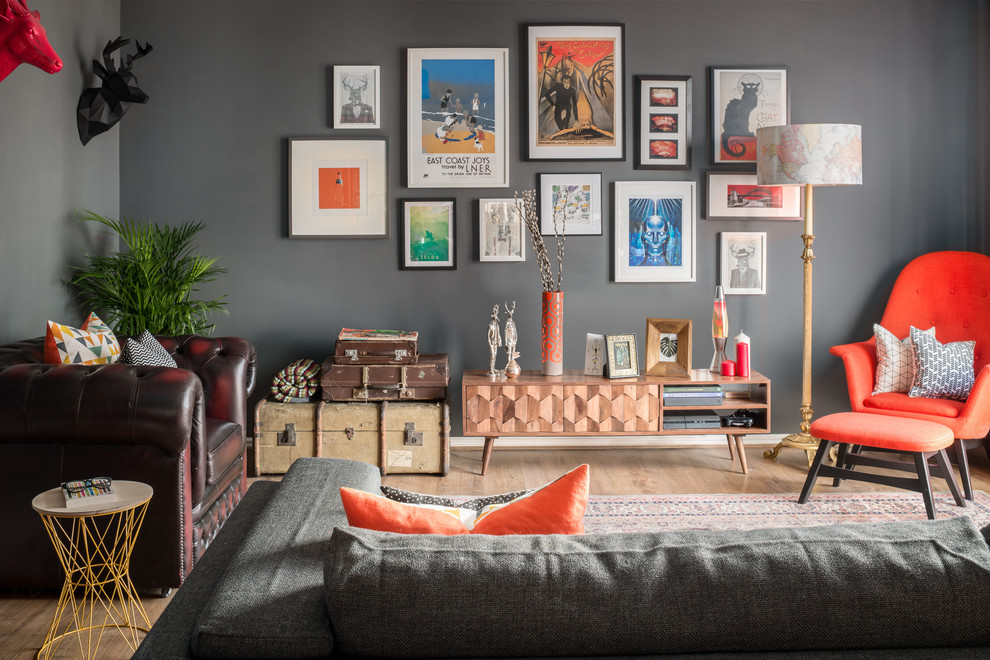 Example of a large eclectic open concept medium tone wood floor and brown floor living room design in Other with gray walls and no fireplace