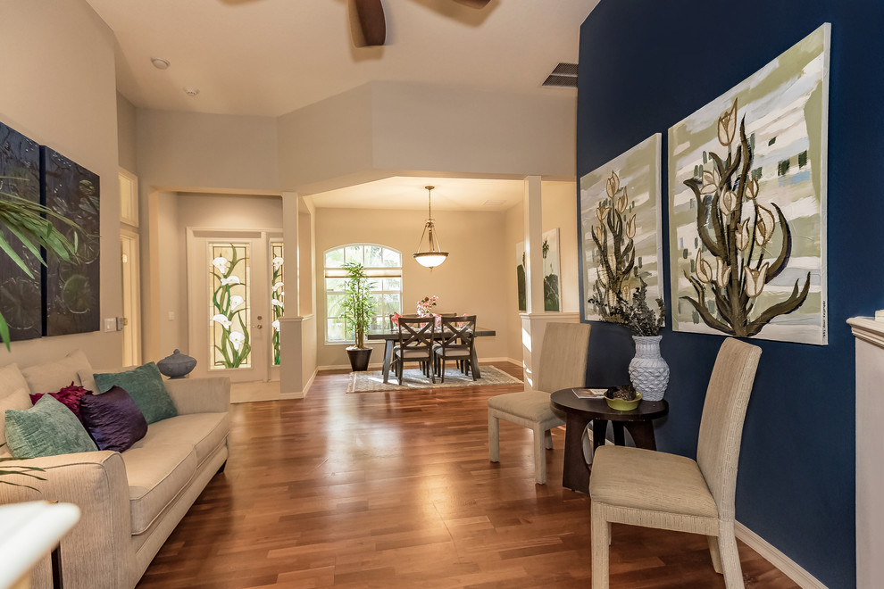 Esempio di un grande soggiorno design aperto con pareti beige, pavimento in legno massello medio e pavimento marrone