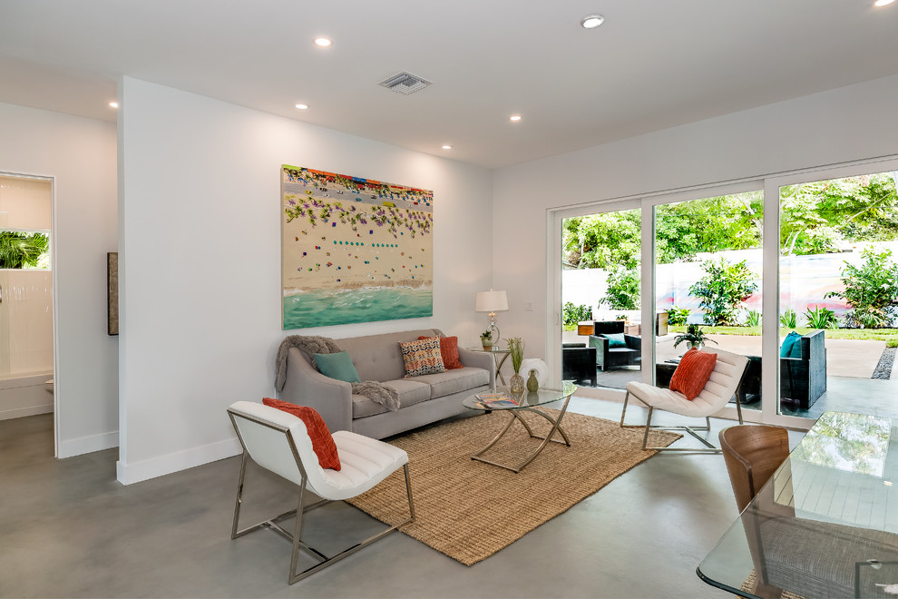 Großes, Offenes Modernes Wohnzimmer mit weißer Wandfarbe, Betonboden und grauem Boden in Tampa