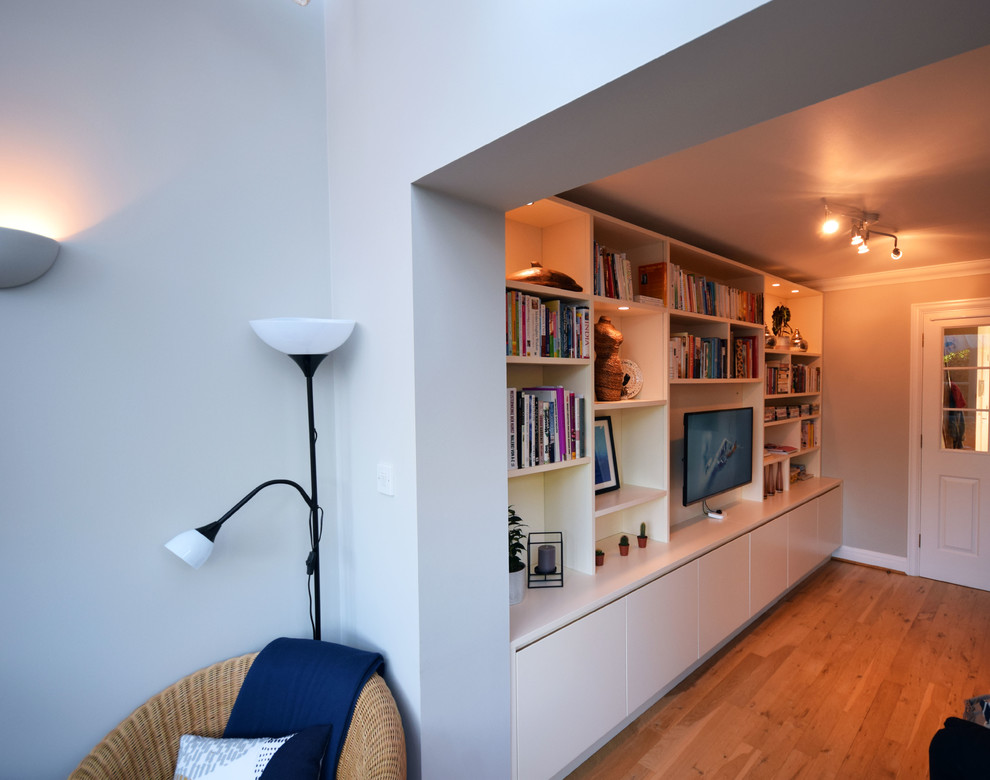 Idéer för att renovera ett mellanstort funkis allrum med öppen planlösning, med grå väggar, mellanmörkt trägolv, en väggmonterad TV och brunt golv