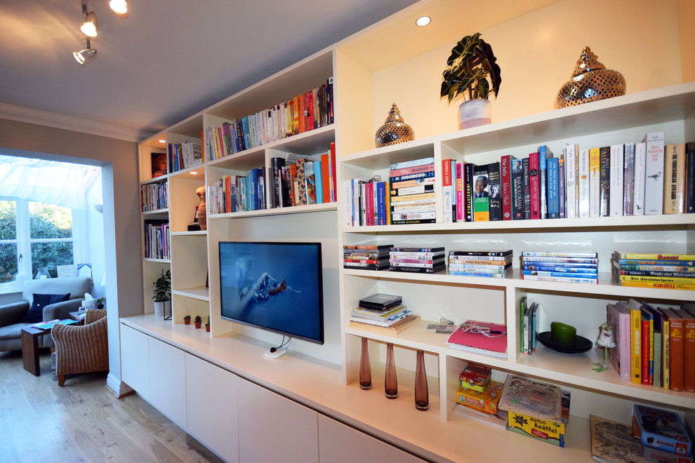 Mittelgroßes, Offenes Modernes Wohnzimmer mit grauer Wandfarbe, braunem Holzboden, TV-Wand und braunem Boden in London