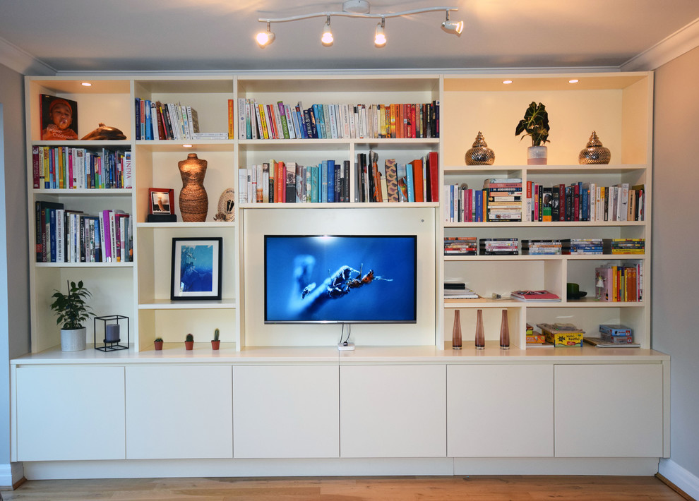 Réalisation d'un salon design de taille moyenne et ouvert avec un mur gris, un sol en bois brun, un téléviseur fixé au mur et un sol marron.