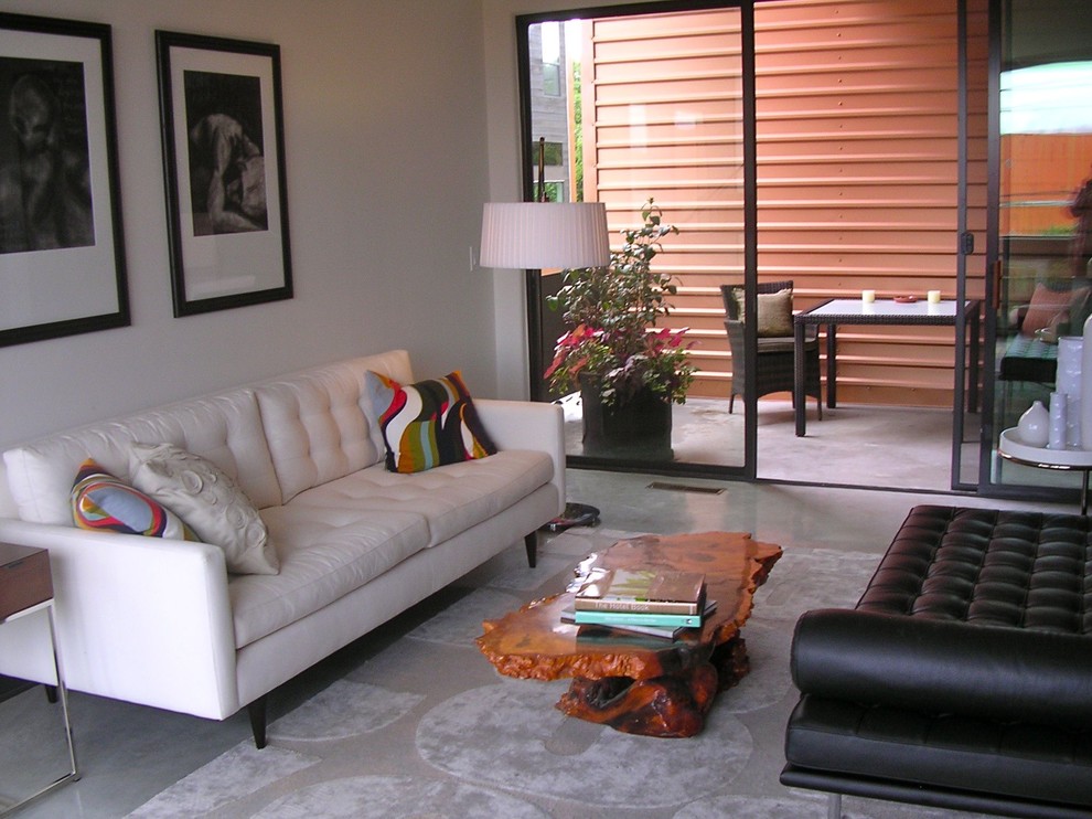 Esempio di un soggiorno minimalista chiuso con pavimento in cemento
