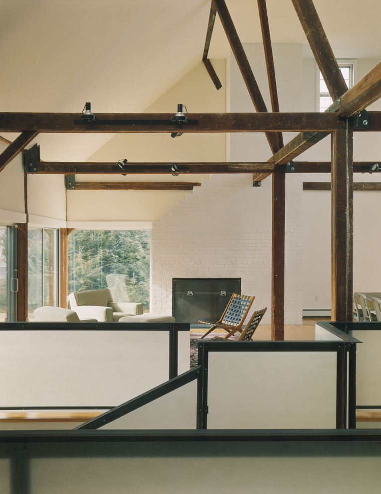 Ispirazione per un soggiorno minimalista stile loft con pareti beige e camino classico