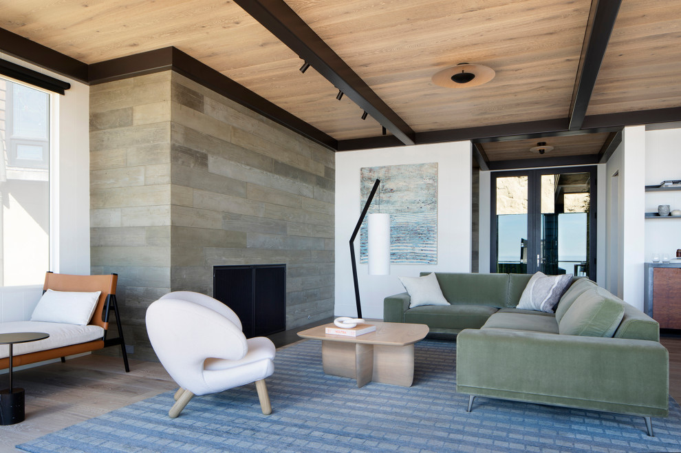 Inspiration för moderna vardagsrum, med ljust trägolv, en öppen hörnspis och en spiselkrans i betong