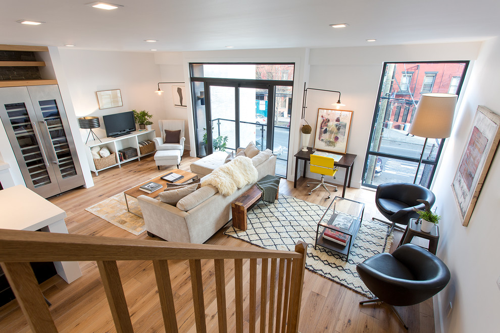 Großes, Repräsentatives, Offenes Modernes Wohnzimmer ohne Kamin mit weißer Wandfarbe, hellem Holzboden, freistehendem TV und braunem Boden in New York
