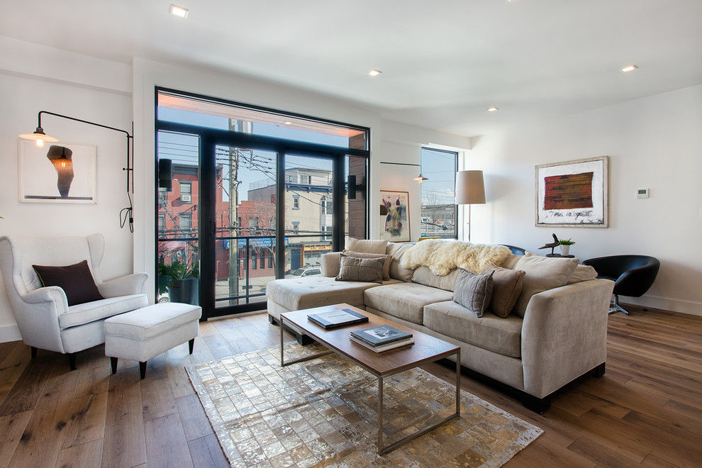 Offenes, Repräsentatives, Großes Modernes Wohnzimmer ohne Kamin mit weißer Wandfarbe, hellem Holzboden, braunem Boden und freistehendem TV in New York