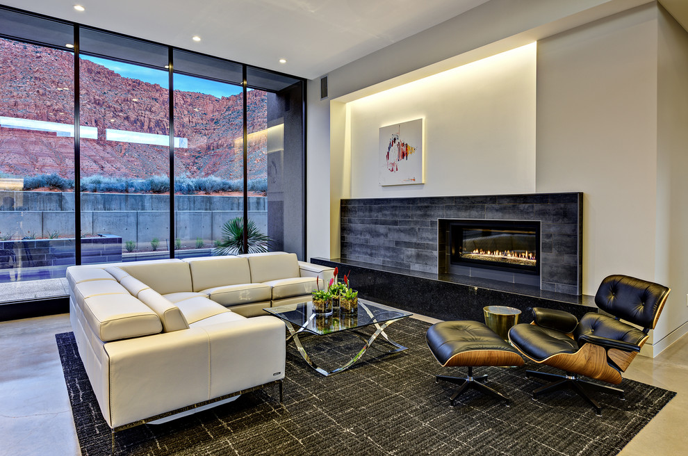 Пример оригинального дизайна: парадная, открытая гостиная комната среднего размера в современном стиле с бежевыми стенами, бетонным полом, серым полом и фасадом камина из плитки без камина, телевизора