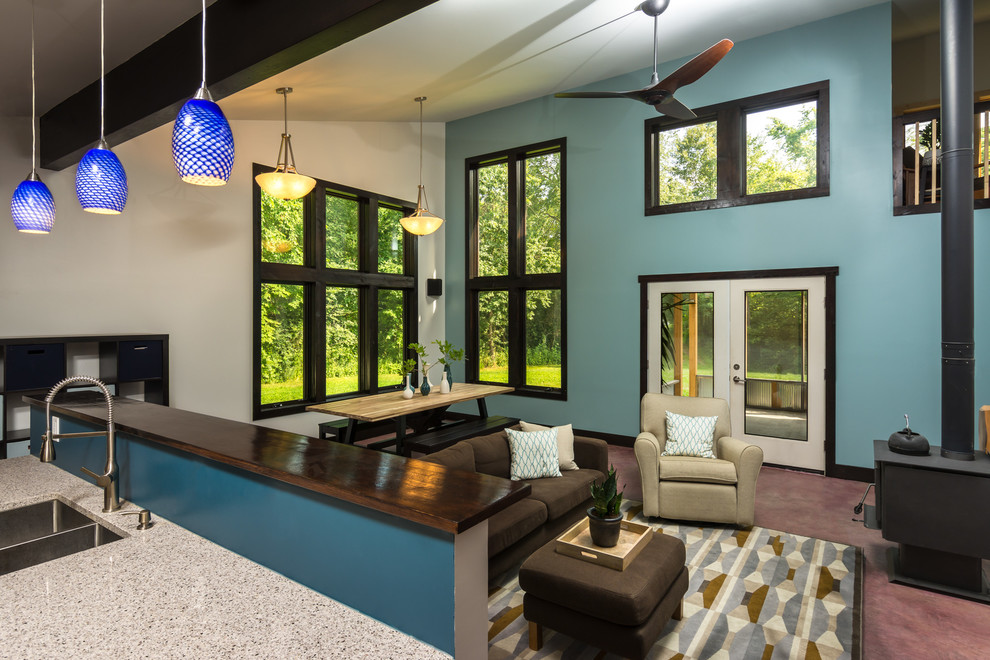 Immagine di un ampio soggiorno moderno aperto con pareti blu, moquette e stufa a legna