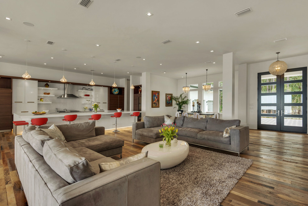 Offenes Modernes Wohnzimmer mit weißer Wandfarbe und braunem Holzboden in Miami