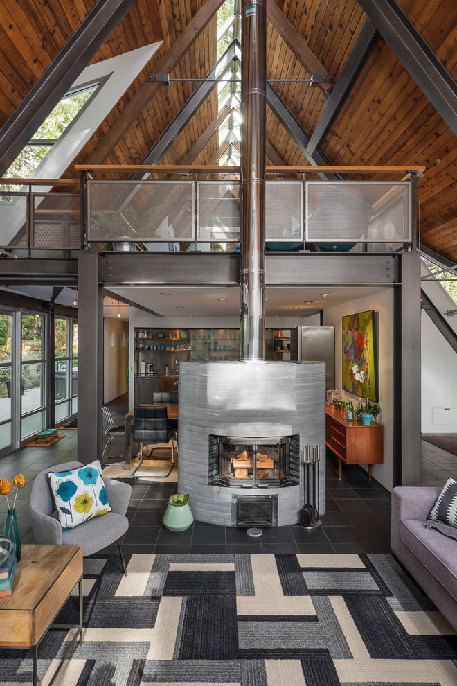 Medium sized industrial mezzanine living room in Seattle with white walls, slate flooring, a two-sided fireplace, a stone fireplace surround and a freestanding tv.