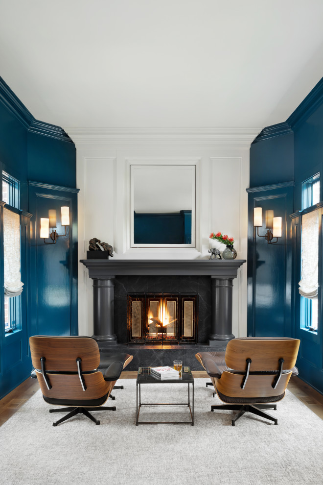 На фото: гостиная комната в стиле неоклассика (современная классика) с синими стенами, паркетным полом среднего тона, стандартным камином, коричневым полом и панелями на части стены