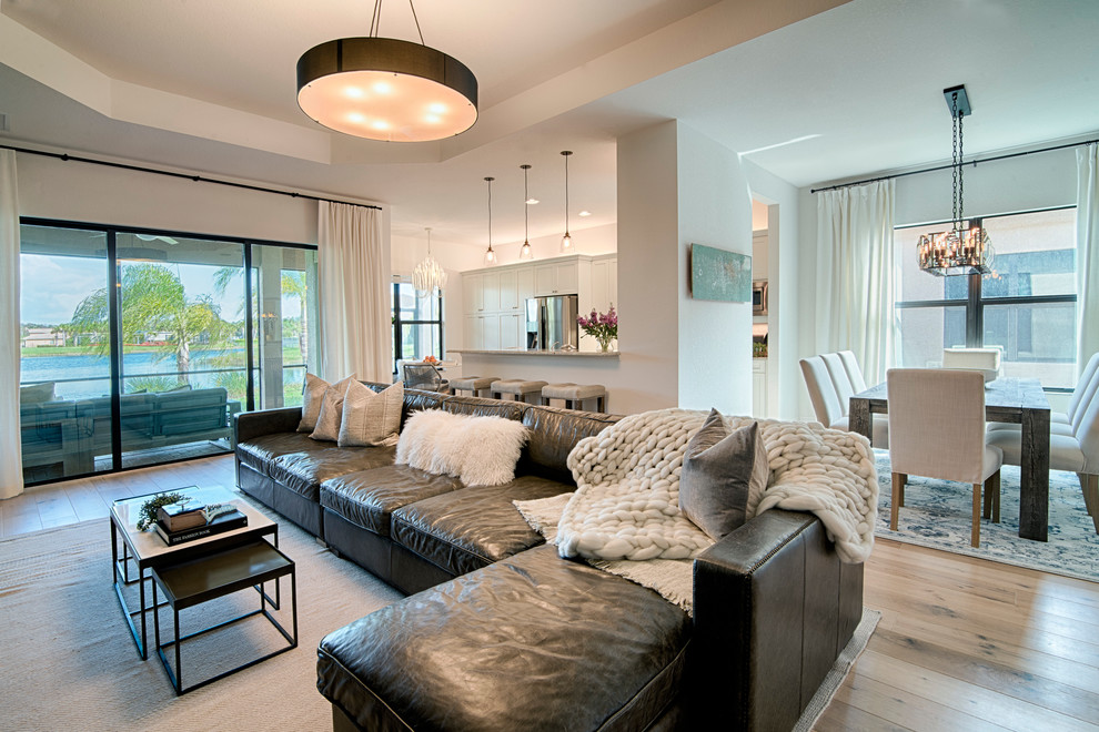 Medium sized coastal living room in Miami with white walls and light hardwood flooring.