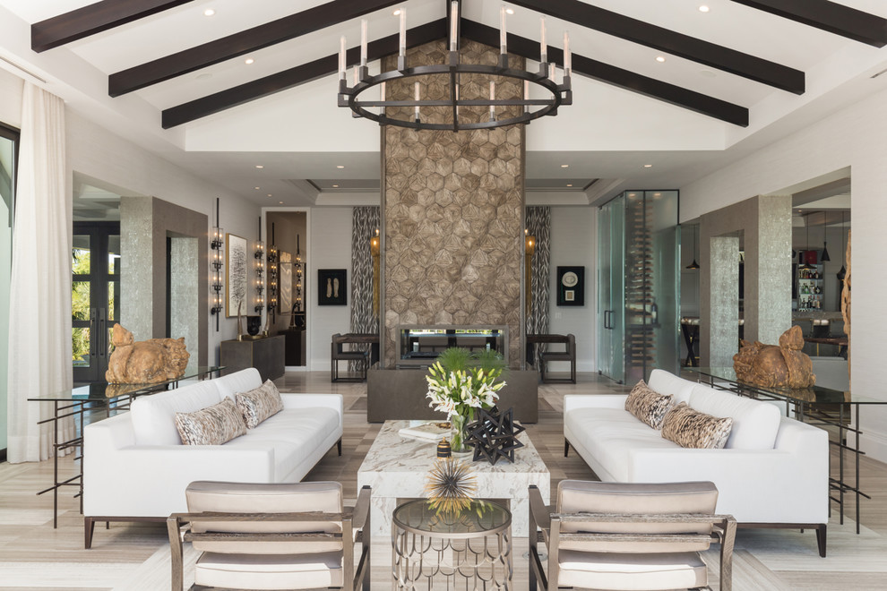 This is an example of a coastal formal living room in Tampa with grey walls, a two-sided fireplace and beige floors.