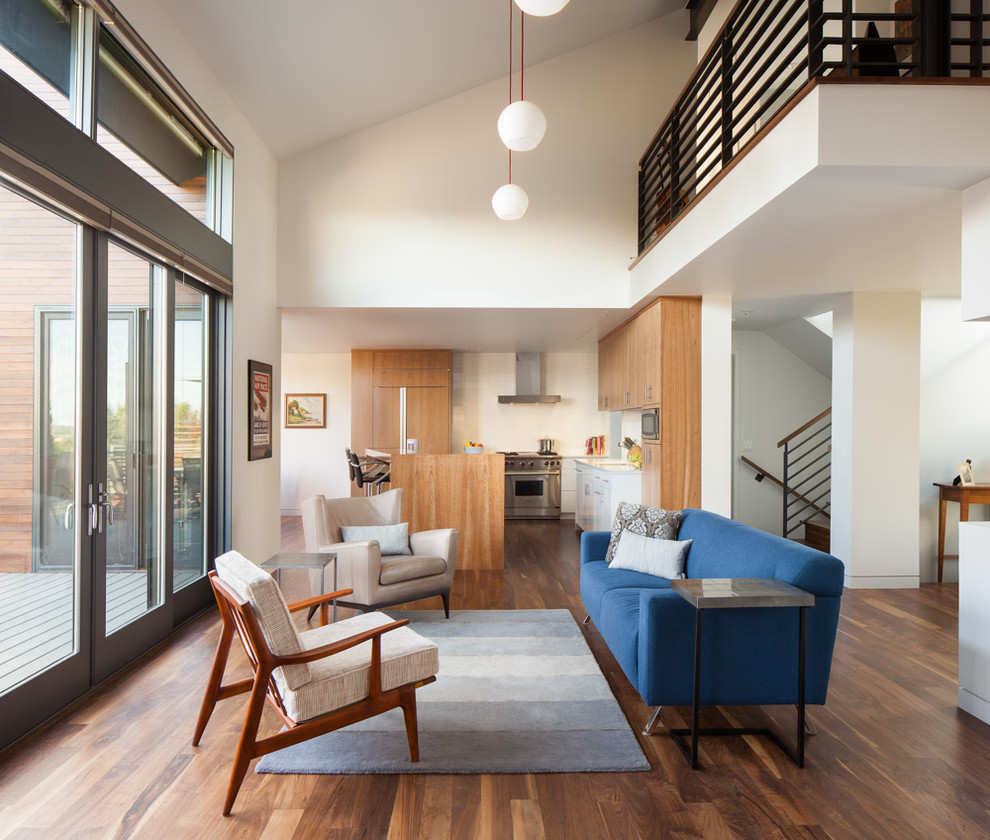 Пример оригинального дизайна: открытая гостиная комната в современном стиле с белыми стенами и синим диваном