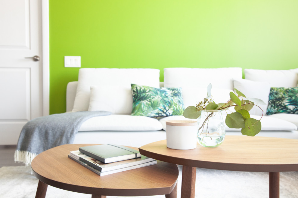 Inspiration för mellanstora moderna allrum med öppen planlösning, med gröna väggar, laminatgolv, en väggmonterad TV och grått golv