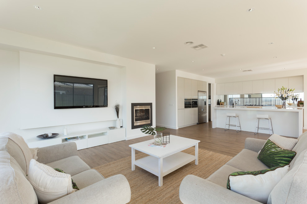 Mittelgroßes, Offenes Modernes Wohnzimmer mit weißer Wandfarbe, braunem Holzboden, Kamin, verputzter Kaminumrandung und TV-Wand in Melbourne