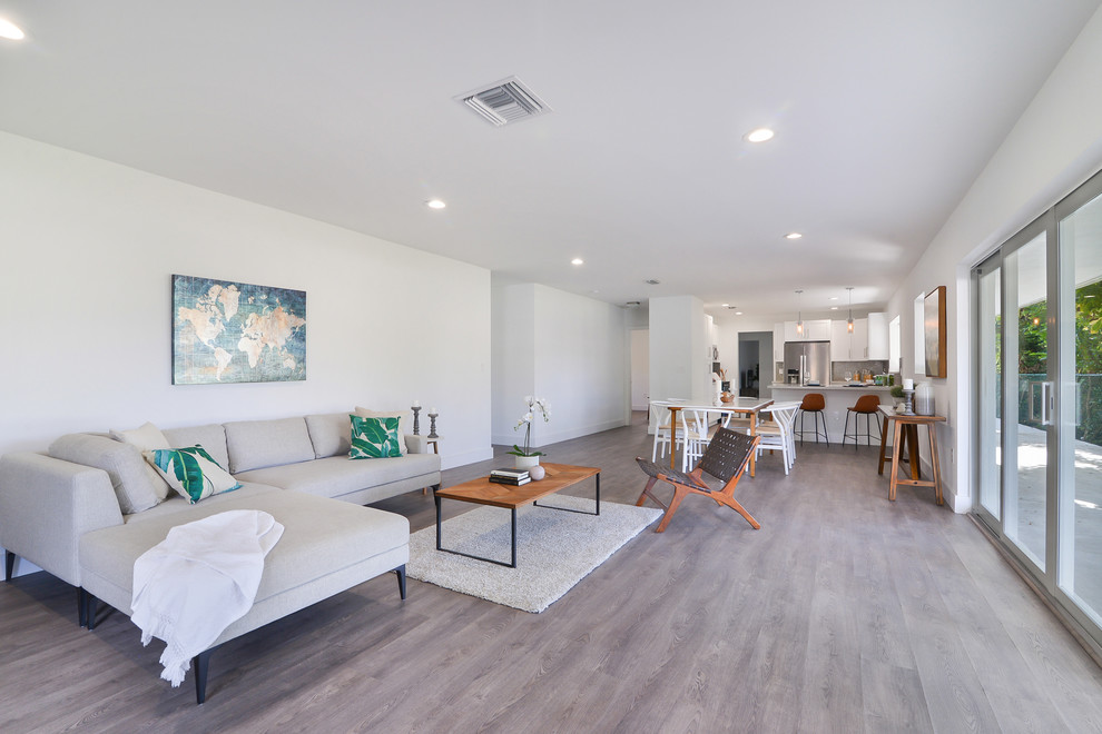 Стильный дизайн: открытая гостиная комната среднего размера в современном стиле с белыми стенами без камина - последний тренд