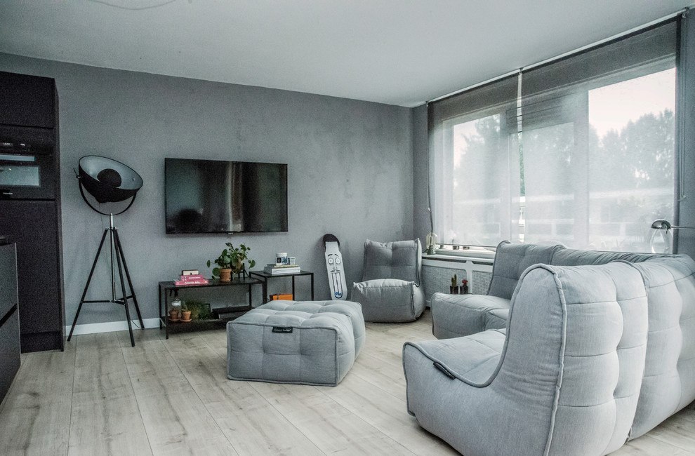 Photo of an expansive contemporary formal open plan living room in Berlin with grey walls, laminate floors, a wall mounted tv, multi-coloured floors and no fireplace.