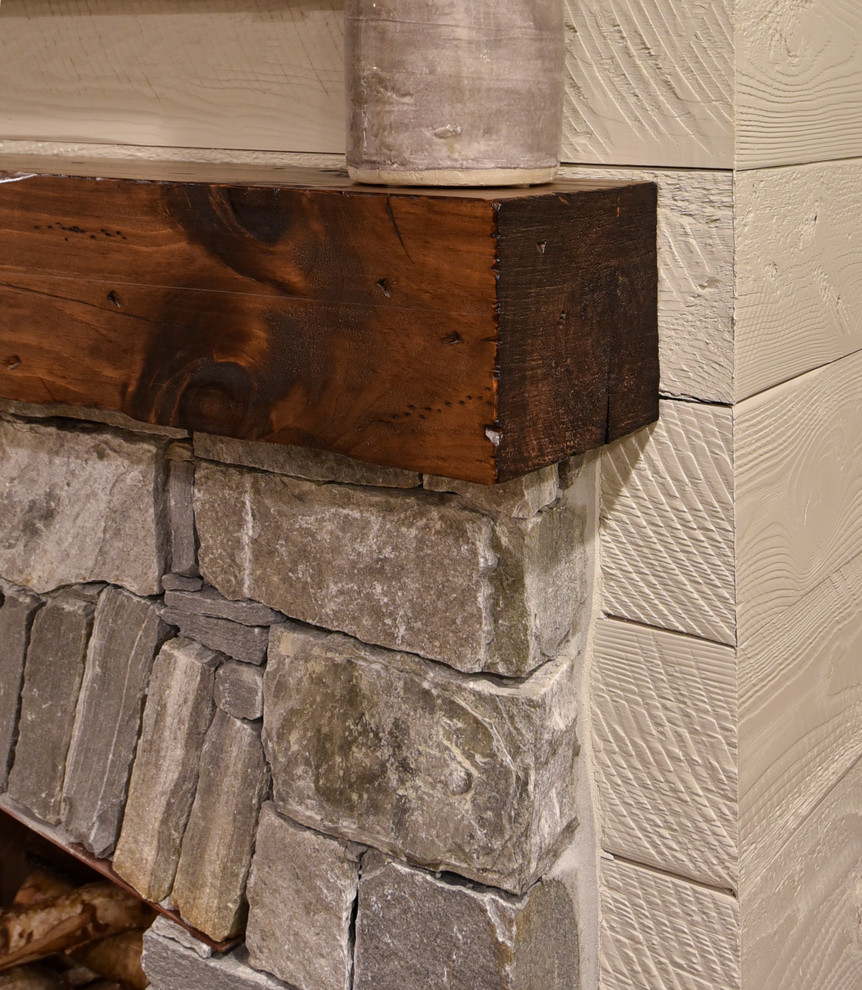 Aménagement d'un salon craftsman ouvert avec un mur beige, une cheminée standard et un manteau de cheminée en pierre.