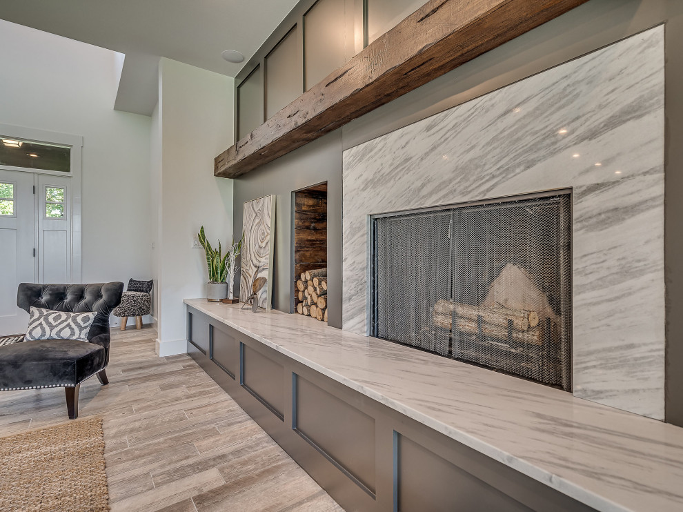 高級な広いトラディショナルスタイルのおしゃれなLDK (白い壁、セラミックタイルの床、標準型暖炉、石材の暖炉まわり、コーナー型テレビ、グレーの床) の写真