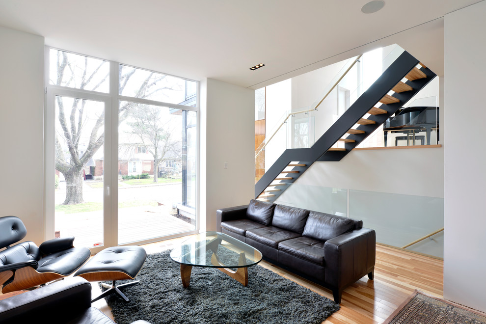 Modern formal open plan living room in Ottawa with white walls and medium hardwood flooring.