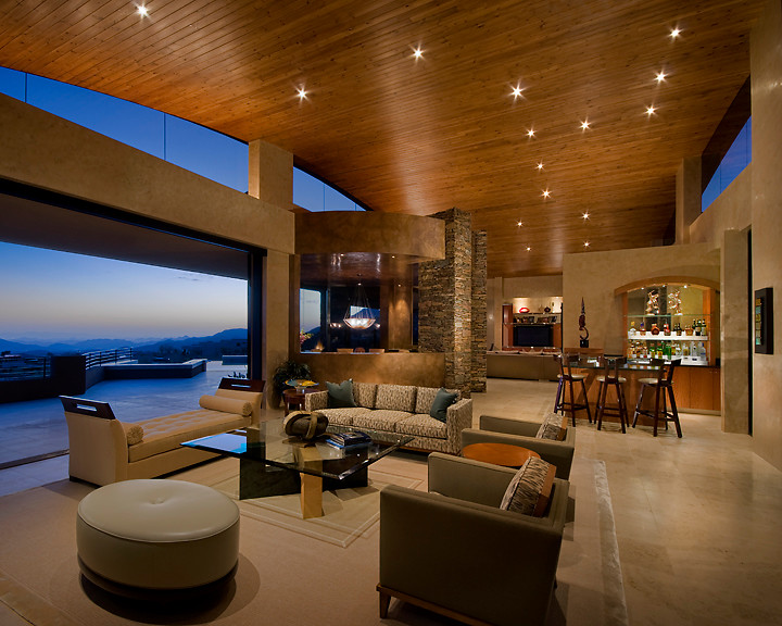 Living room - huge modern open concept limestone floor living room idea in Phoenix with beige walls, a standard fireplace, a stone fireplace and a bar