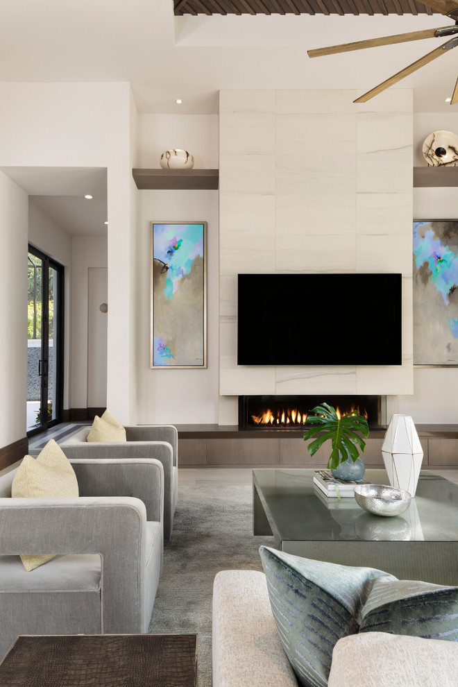 Свежая идея для дизайна: большая открытая гостиная комната в стиле модернизм с белыми стенами, полом из керамогранита, телевизором на стене, бежевым полом, горизонтальным камином и фасадом камина из плитки - отличное фото интерьера