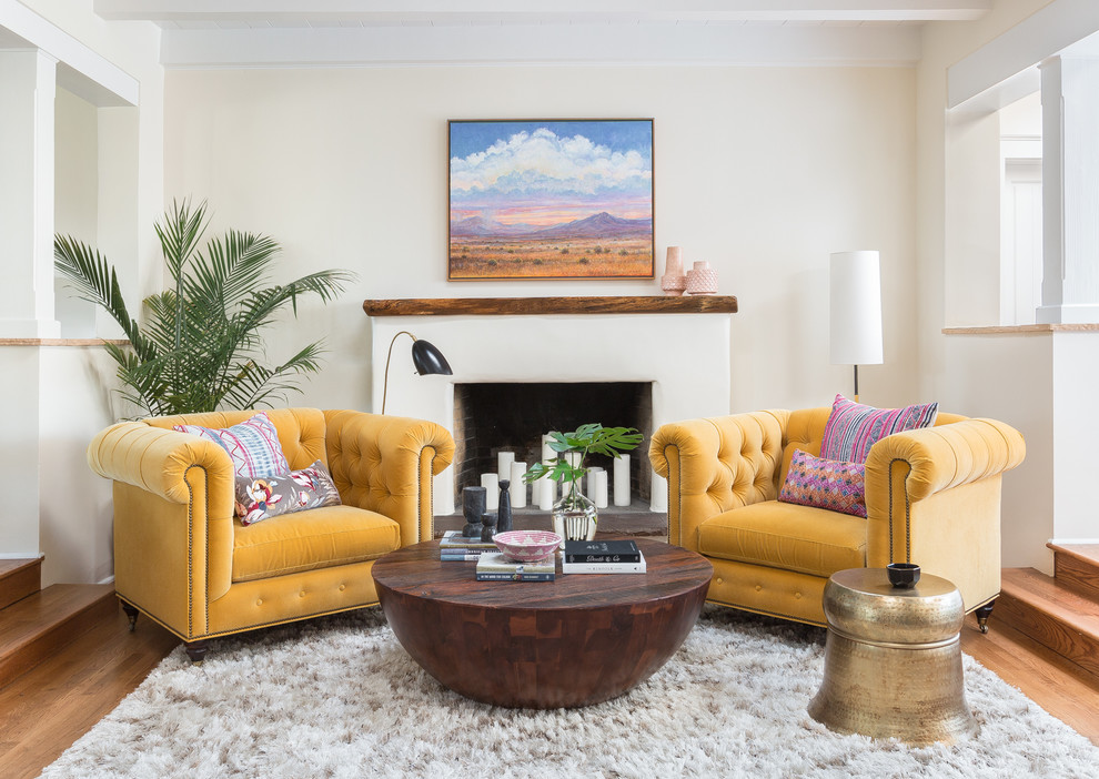 Idée de décoration pour un salon minimaliste avec un mur blanc, un sol en bois brun, une cheminée standard et un manteau de cheminée en plâtre.