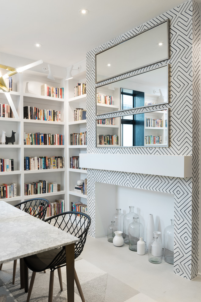 Idee per un soggiorno moderno di medie dimensioni e chiuso con libreria, pareti bianche, pavimento in cemento, camino classico e cornice del camino in cemento