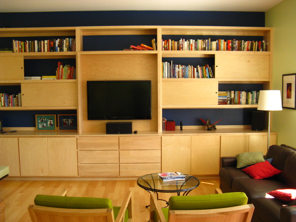 Idéer för att renovera ett stort funkis allrum med öppen planlösning, med ett bibliotek, blå väggar, ljust trägolv och en inbyggd mediavägg