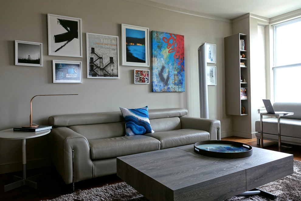 Inspiration pour un petit salon design fermé avec un mur gris, un sol en bois brun, un téléviseur encastré et un sol marron.