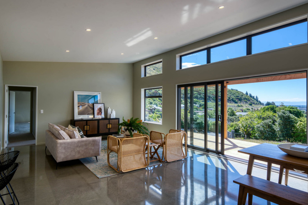 Идея дизайна: открытая гостиная комната среднего размера в современном стиле с бетонным полом, сводчатым потолком и зелеными стенами
