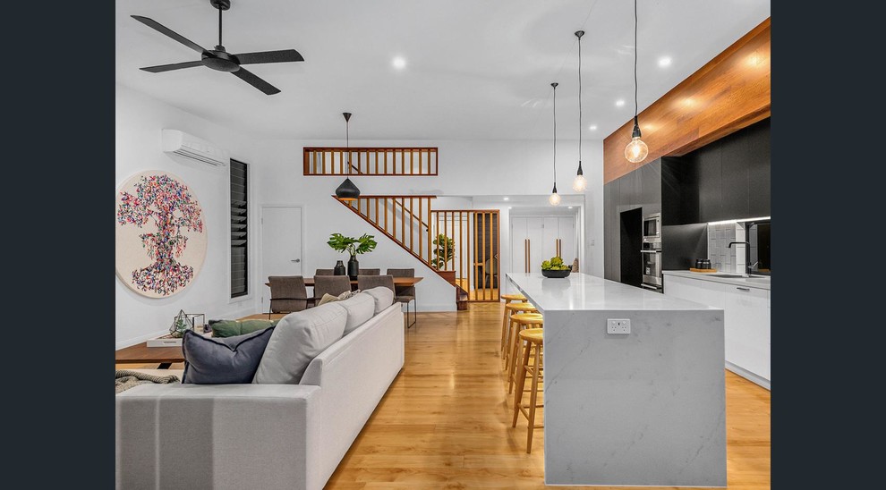Immagine di un soggiorno moderno di medie dimensioni e aperto con pareti bianche, pavimento in legno massello medio e pavimento marrone