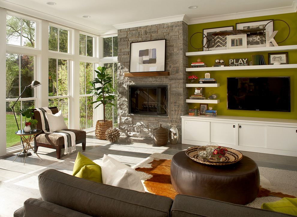 Idéer för ett lantligt vardagsrum, med gröna väggar, en spiselkrans i sten och en väggmonterad TV