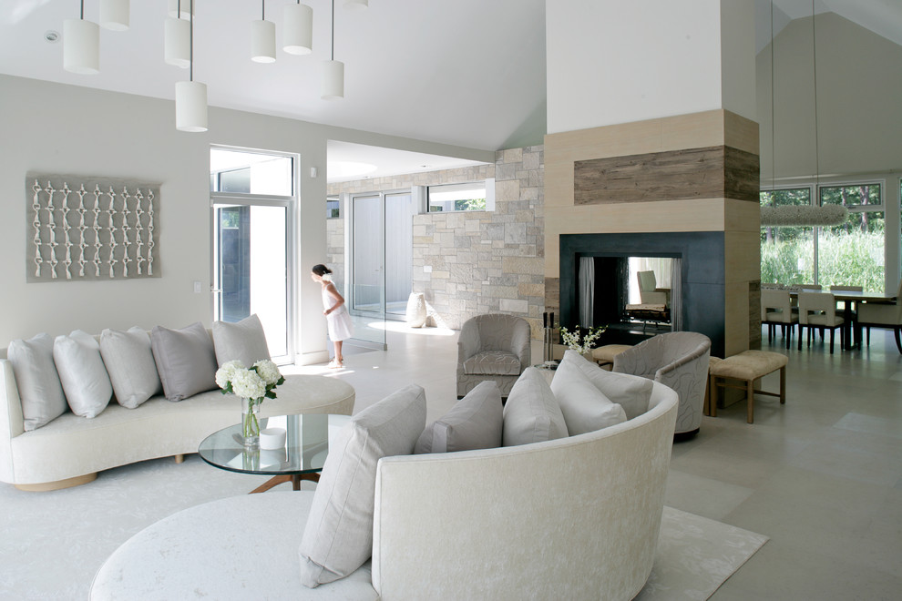 Стильный дизайн: открытая гостиная комната среднего размера в стиле кантри с серыми стенами, полом из известняка, двусторонним камином и бежевым полом без телевизора - последний тренд